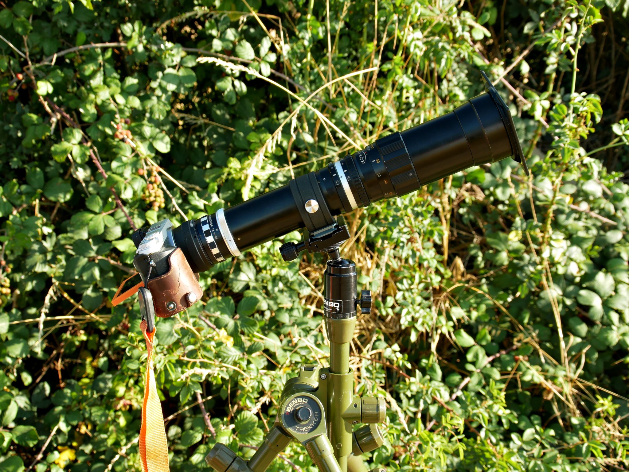2026-08-12 Lumix DMC-GX7 camera with Hanimex 400mm lens and Tamron 2x Teleconverter mounted on Benbo Trekker tripod, with generic Arca-type quick release. Sun filter is a 90 mm x 110 mm welding glass, glued to a 72 mm - 82 mm step-up ring using black silicone bath sealer.