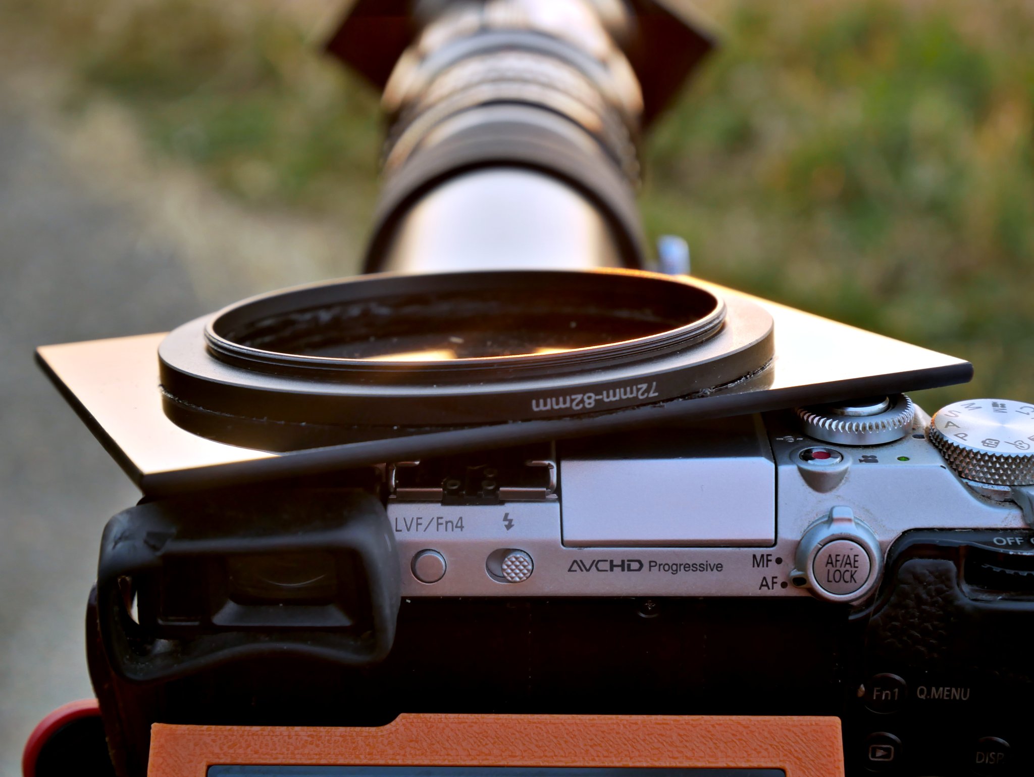 2026-08-12 Lumix DMC-GX7 camera with Hanimex 400mm lens and Tamron 2x Teleconverter mounted on Benbo Trekker tripod, with generic Arca-type quick release. Sun filter is a 90 mm x 110 mm welding glass, glued to a 72 mm - 82 mm step-up ring using black silicone bath sealer.