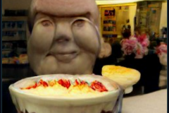 craiyon_001052_Ian_Hislop_stuffed_head_first_into_a_large_bowl_of_trifle_br_