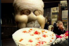 craiyon_001055_Ian_Hislop_stuffed_head_first_into_a_large_bowl_of_trifle_br_