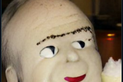 craiyon_001115_Ian_Hislop_stuffed_head_first_into_a_large_bowl_of_trifle_br_