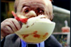 craiyon_001308_Ian_Hislop_pushed_head_first_into_a_large_bowl_of_trifle_br_