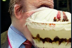 craiyon_001319_Ian_Hislop_pushed_head_first_into_a_large_bowl_of_trifle_br_