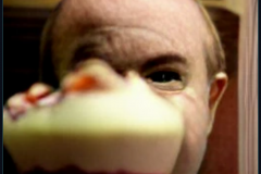 craiyon_001324_Ian_Hislop_pushed_head_first_into_a_large_bowl_of_trifle_br_