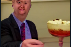 craiyon_002017_Ian_Hislop_pushed_face_first_into_a_large_bowl_of_trifle_br_