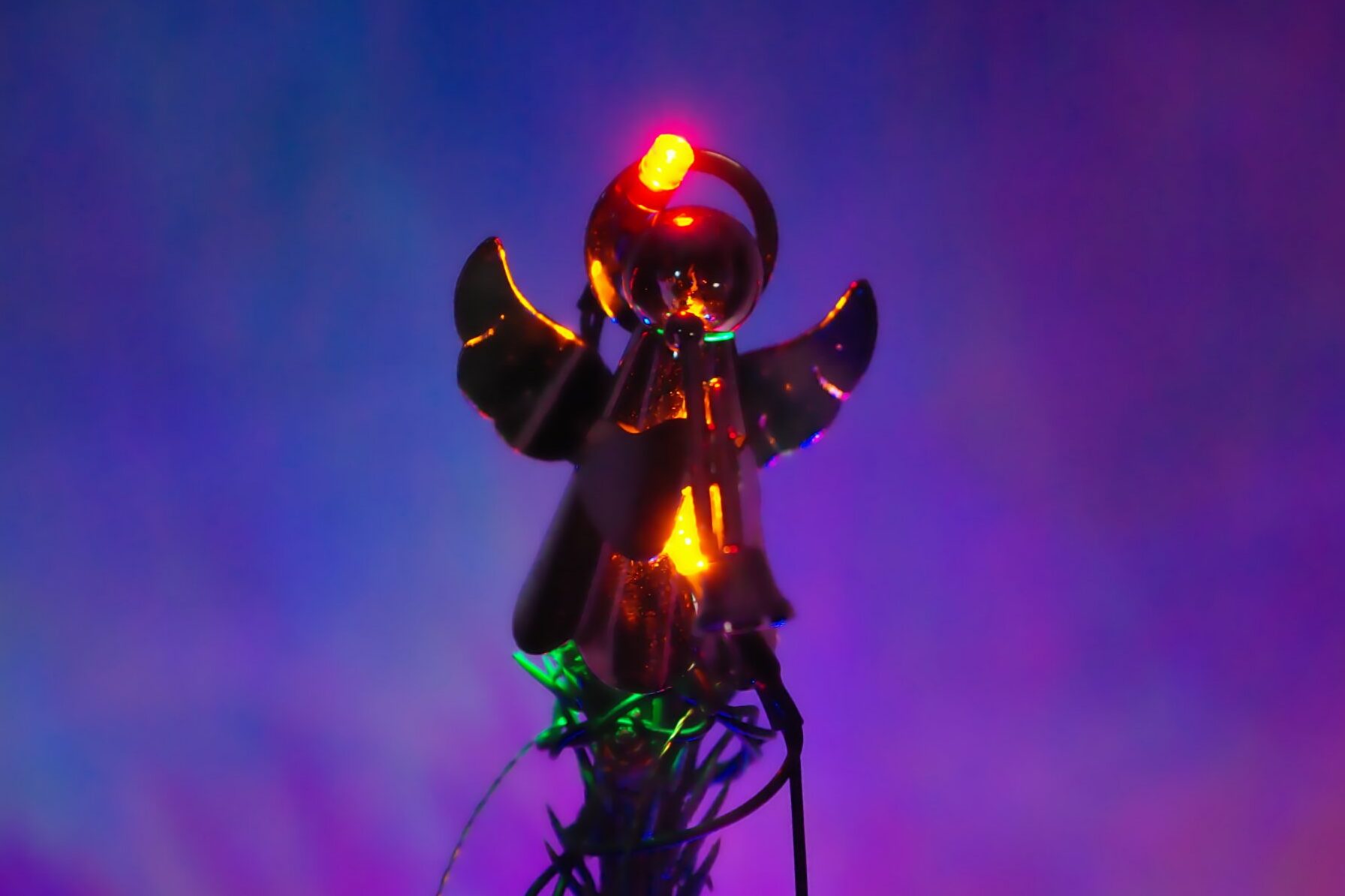 Metal angel on the Christmas tree, lit by LED.